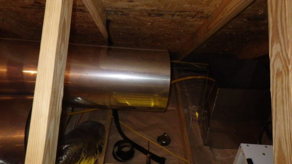 Stainless steel duct being installed in a crawlspace